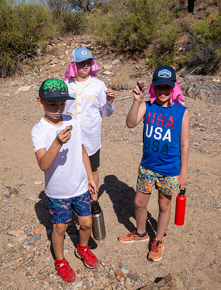 Sonoran scientists hold up rocks that they have found